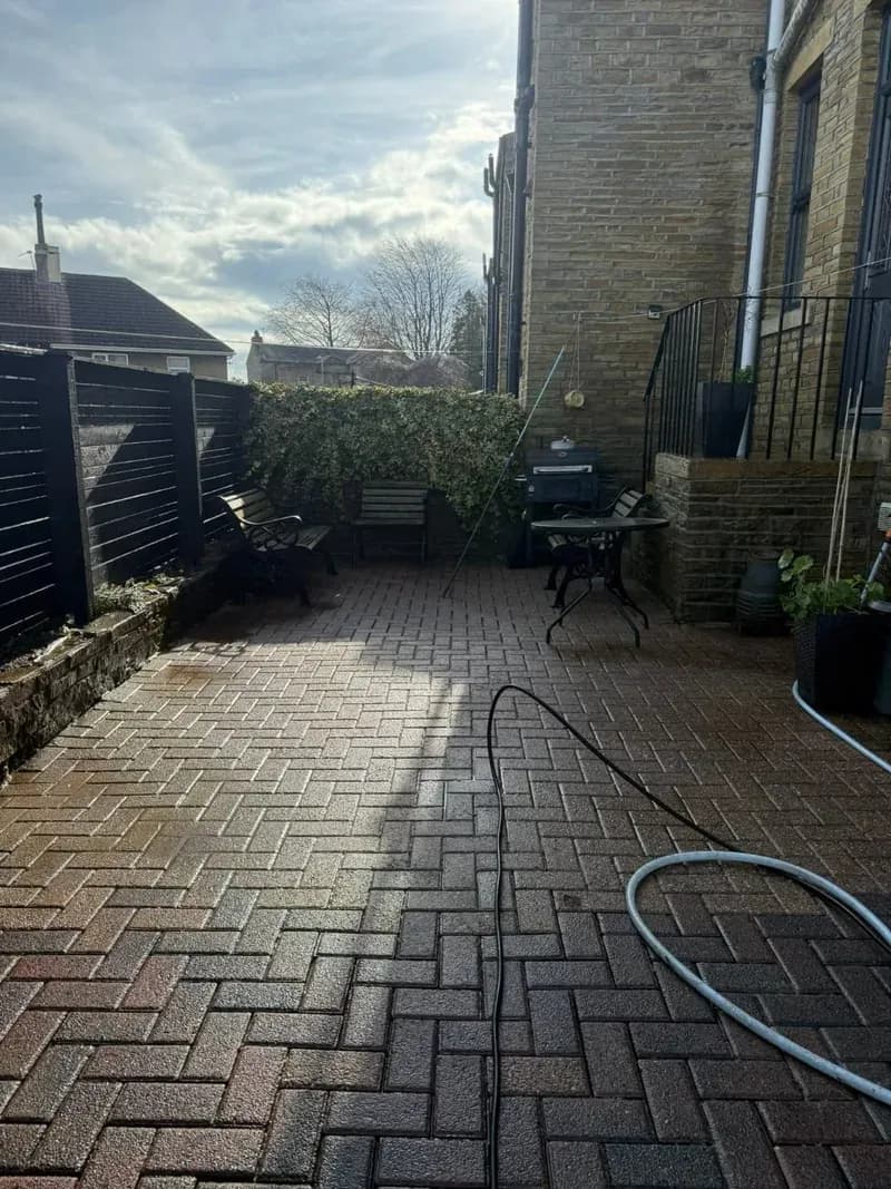 Back yard block paving restored to a clean warm red finish after pressure washing, benches and seating area back in use