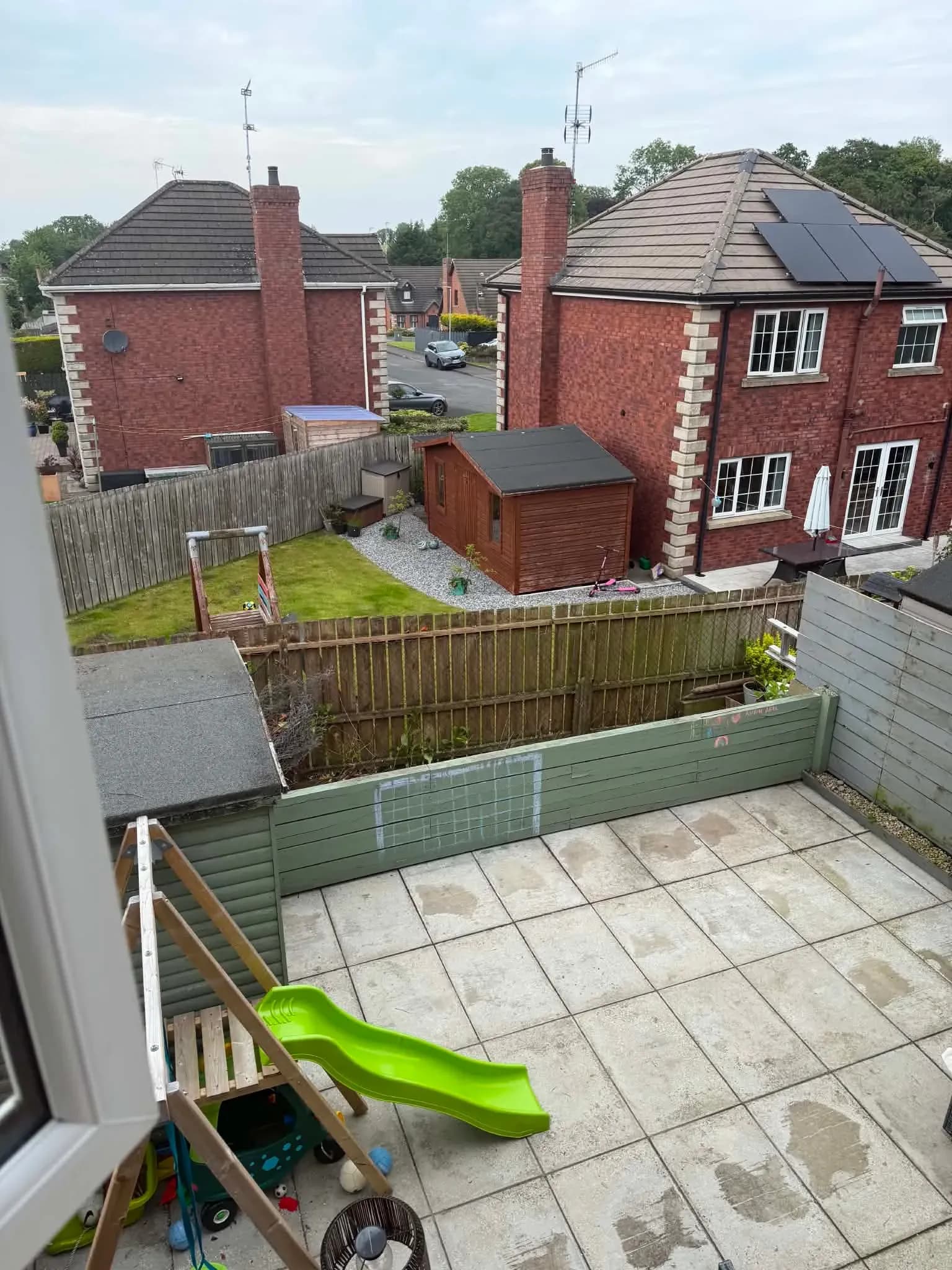 The same patio flooded with light after complete laurel hedge removal, garden and fence line fully opened up